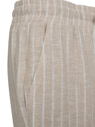 closeup af beige bukser med shiny hvide lodrette striber, sidelommer, brede bukseben og elastik i taljen. Freequent Sand Melange Off-White FQLALUX-PANTS