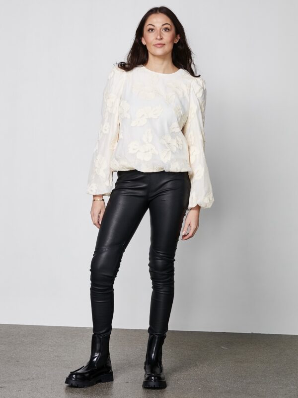 model med langærmet hvid bluse med rund hals, broderet blomsterdetaljer og ballonærmer. NÜ Yan Blouse creme 8353-50