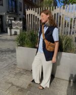 Marie med denimvest over blå t-shirt til beige bukser