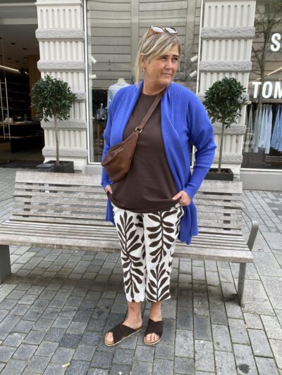 janni med blå cardigan over bluse til mønstret bukser med palmeblade