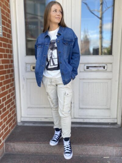 Marie med denimjakke, t-shirt med print og hvide bukser