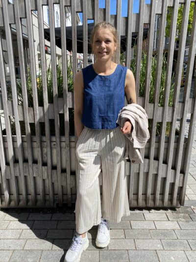Maire med blå top i denim og beige bukser