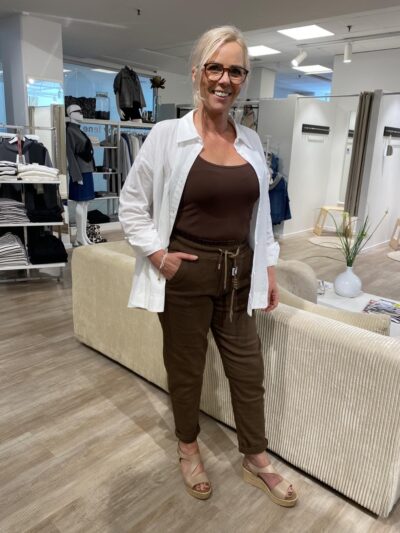 Lene med brun top, hvid åben skjorte og brune joggingbukser fra mind by lene