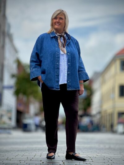 Janni med blå denimskjorte og brune bukser