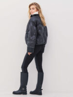 siden af model med kort sort jakke i pufferstil med teddykrave. NÜ Arisa Jacket Black