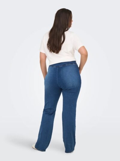 ryggen af model med blå jeans med bred elastik i taljen. ONLY Carmakoma CARROYAL Flared Legging Medium Blue Denim
