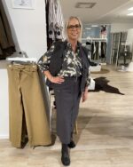 lene med mørkegrå nederdel og vest samt mønstret bluse