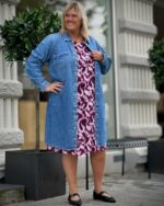 janni med åben denimkjole over pink mønstret kjole