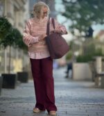 lene med lyserød skjorte, strik samt røde bukser og taske