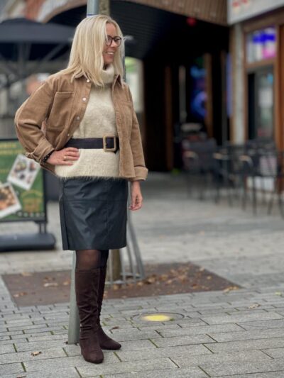 Lene med brun jakke, hvid strikvest og sort lædernederdel