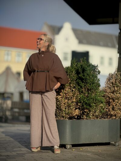 Lene med brun poncho og brune ternede bukser