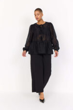 model med sorte bukser og transparent sort bluse med bindebånd. Wasabi WA-SANNA 1 Bluse Black
