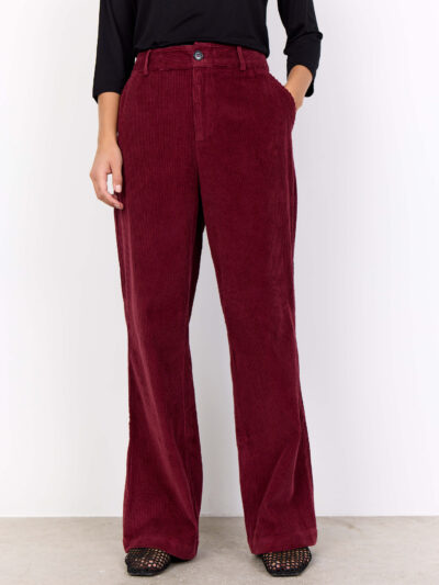 modle med hån i lommen på røde bukser i fløjl. Soyaconcept SC-BINDI 19-C Bukser Dark Red